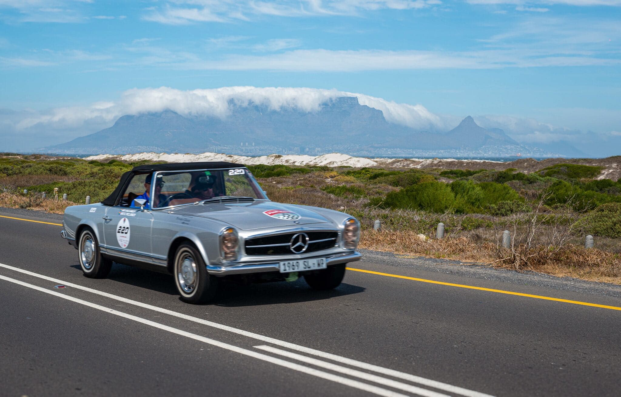 A classic Mercedes-Benz travelling with Table Mountain behind it during The Cape 1000.