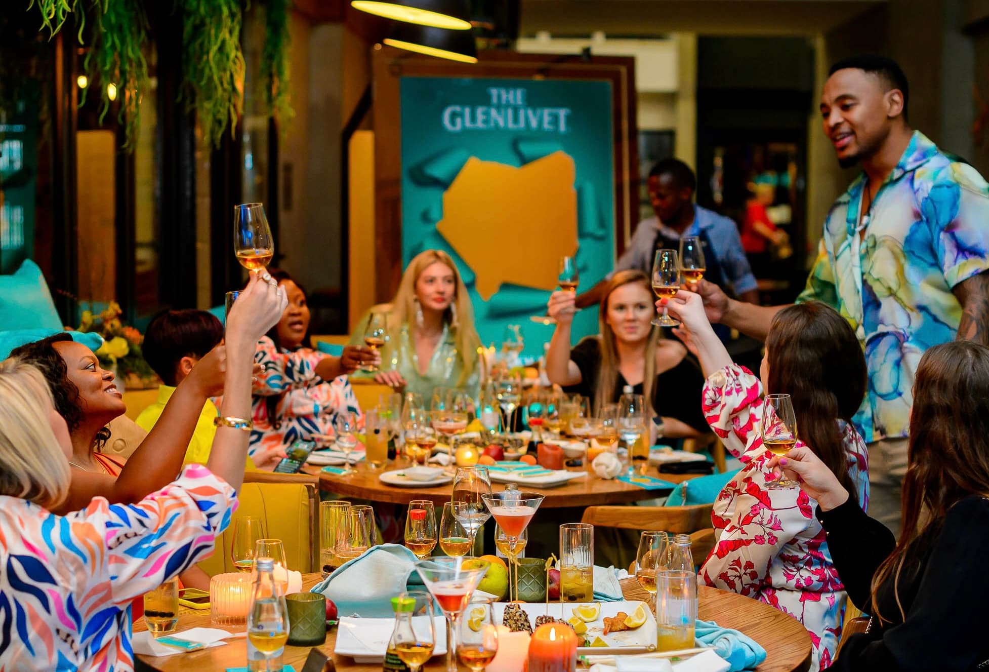 Guests raising glasses together during a Glenlivet dinner experience.