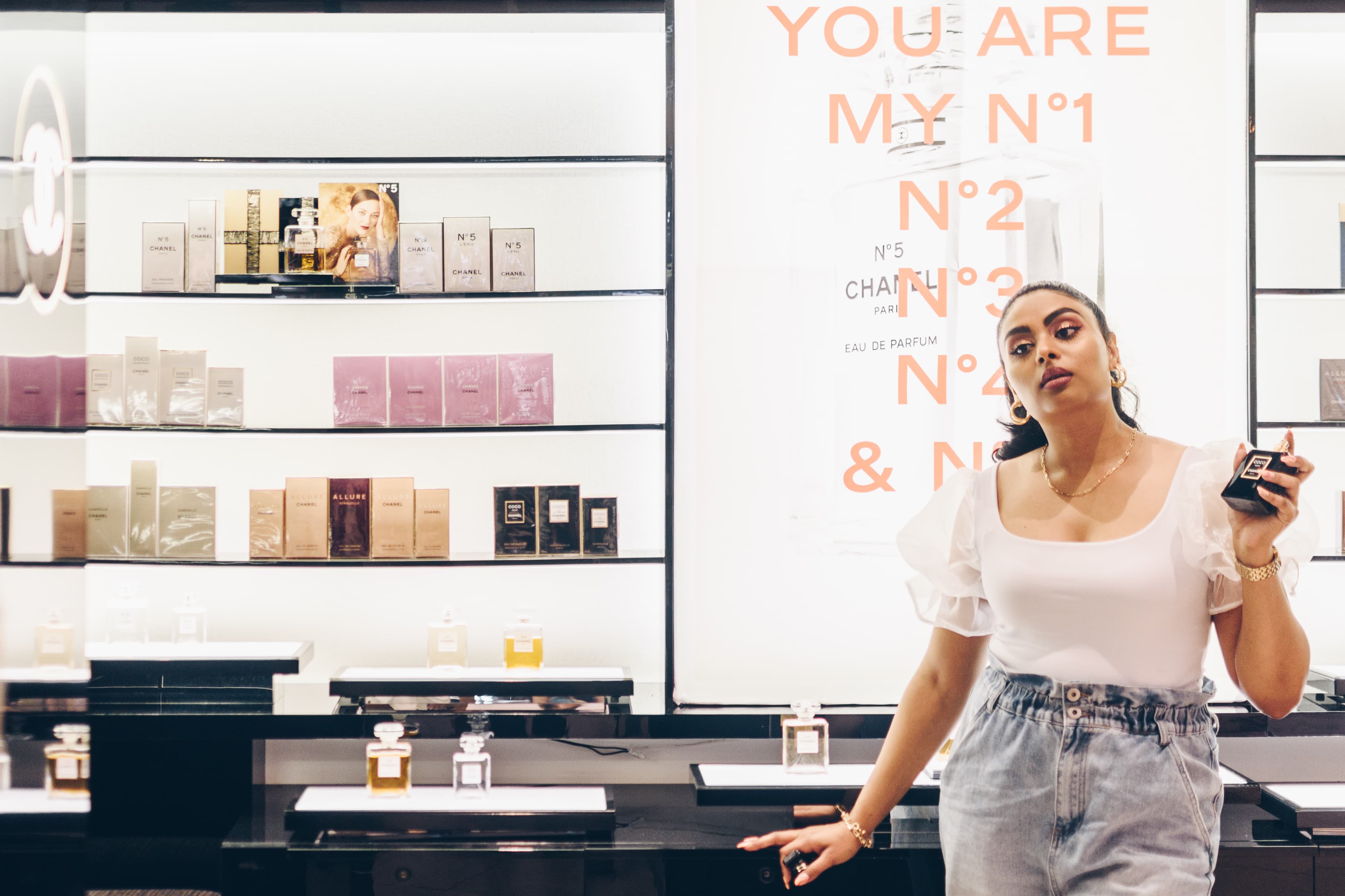 A guest beside a Chanel N°5 mirror display in an Edgars retail environment.