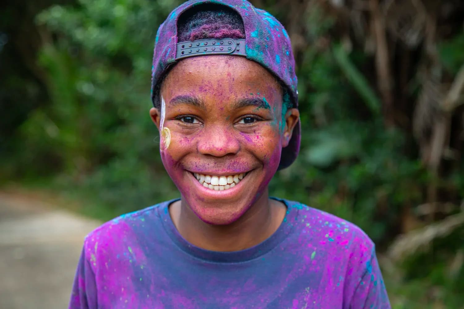 A smiling young participant covered in colour at the Zimbali Colour Run.
